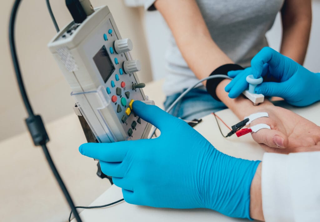 A therapist conducts a nerve test with electromyography (EMG) equipment.