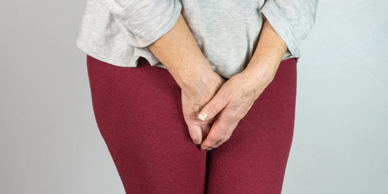 A woman holding urine urgency due to incontinence in menopause.