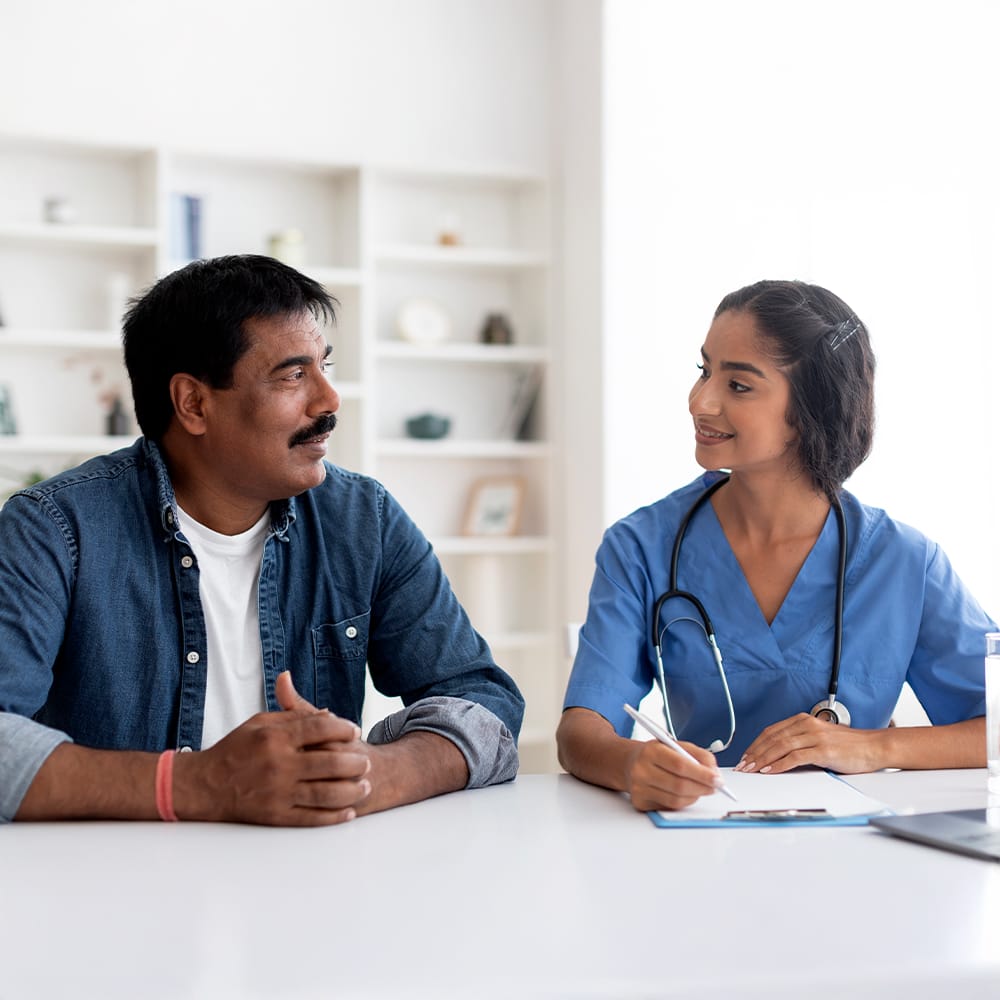 A healthcare worker in conversation with a patient.